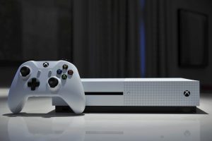 Consola Xbox en color blanco, con control individual sobre una mesa